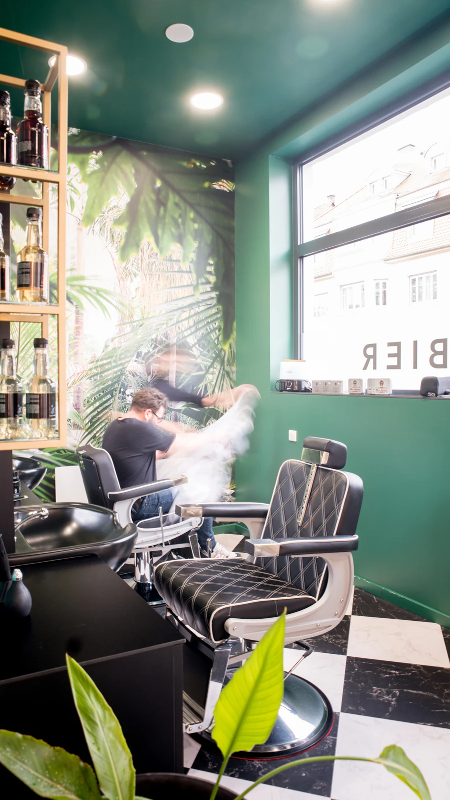 Fauteuil de barbier et décor végétal dans l’espace barbier Tommy & Co à Strasbourg Neudorf