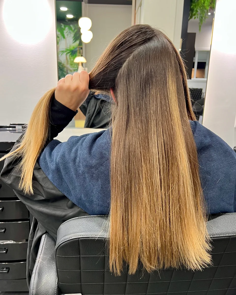 Avant le balayage Airtouch : cheveux longs et lisses, racines plus foncées et longueurs aux reflets dorés